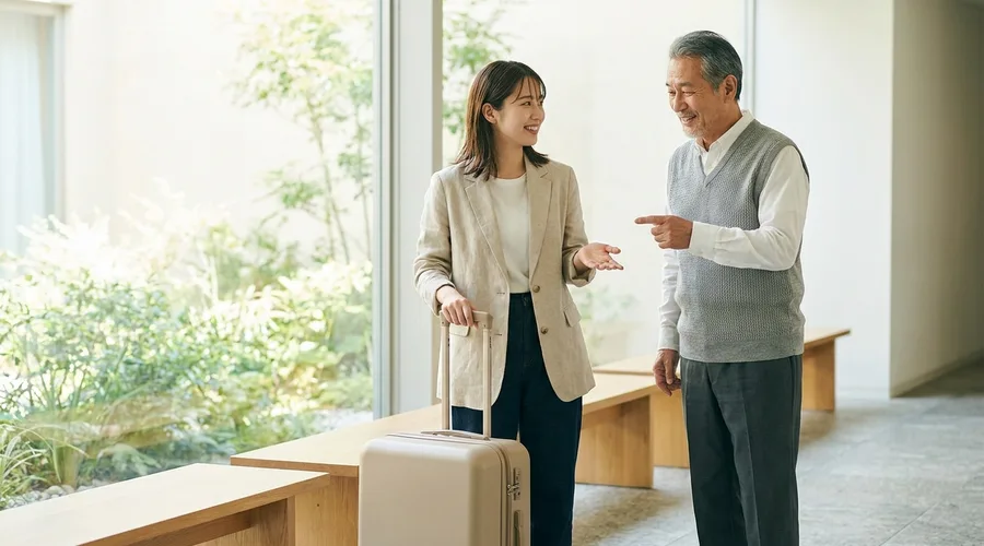 여행 가방을 옆에 두고 길을 묻는 여행자